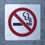 No smoking sign affixed to a wall on a building outside