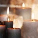Burning candles in front of a festive background