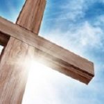 Wooden Cross with a Bright Blue Sky and Sun