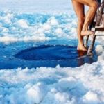 Man is going to swim in the ice hole at sunny day