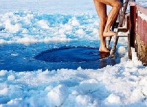 Man is going to swim in the ice hole at sunny day