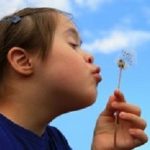 Little girl blowing dandelion
