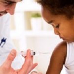 Doctor pediatrician injecting vaccine to cute african girl
