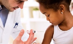 Doctor pediatrician injecting vaccine to cute african girl