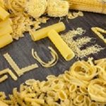 Shapes of pasta and gluten word made of pasta on wooden background