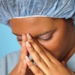 Crying nurse with her hands on her face