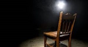 The unique role of doctors in evaluating torture and persecution Isolated wooden chair in a dark scary prison with an interrogation spotlight