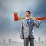 Young determined businessman with axe on shoulder