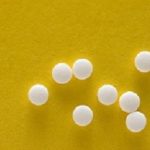 Saccharine tablets on a yellow background.