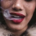 Woman smoking, close up on smoke and mouth