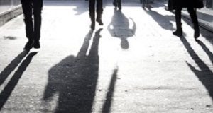 Motsoaledi lashed for saying illegals are burdening health system Blurry shadows of people oin the city sidewalk