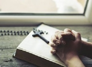 woman hand cross on the book in window background