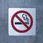 No smoking sign affixed to a wall on a building outside