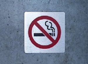 No smoking sign affixed to a wall on a building outside