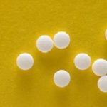 Saccharine tablets on a yellow background.