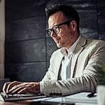 Businessman sitting at his desk and using laptop in the office