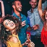 Happy friends doing party at night club – Young woman having fun with her group of mates eating candy lollipops inside disco – People, friendship, nightlife and youth holidays lifestyle