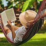 Attractive sexy woman reading book in hammock.