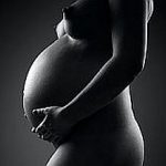 Art nude, sexy naked pregnant woman on black studio background, pregnancy concept