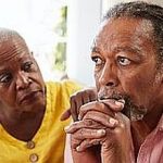 Senior Woman Comforting Man With Depression At Home