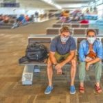 Coronavirus outbreak travel restrictions. Travelers with face mask at international airport affected by flight cancellation and travel ban. COVID-19 pandemic and countries shutdowns.