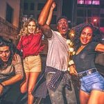 Friends having outdoor party in the city street at night