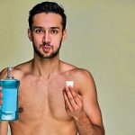 Guy with smile with black hair with a beard rinses his mouth with a remedy. Dental concept