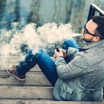 Man with beard vaping outdoor electronic sigarette