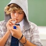 teen boy lighting cigarette