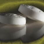 Two Tablets of Asprin Medicine on Black Background