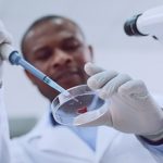 Happy afro-american researcher doing a blood test