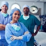 Portrait Of Multi-Cultural Surgical Team Standing In Hospital Operating Theater