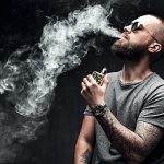Men with beard in sunglasses vaping