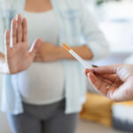 Smoking And Pregnancy. Pregnant Girl Refusing To Take Cigarette Gesturing Stop. pregnant woman with belly refuses passive Smoking. The concept of the rejection of bad habits