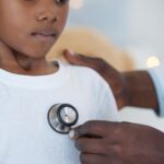 Shot of an unrecognizabl doctor examining a patient with a stethoscope at a hospital