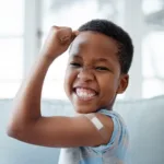 Portrait of a little boy with a plaster on his arm after an injection