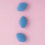 Blue pills viagra on pink background. Top view. Medicine concept of medication for treatment of erectile dysfunction, pulmonary hypertension