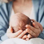 Newborn in mother's hands. Baby care. Childbirth and motherhood concept. Mother and baby
