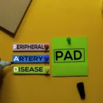 PAD. Peripheral Artery Disease acronym on sticky notes. Office desk background