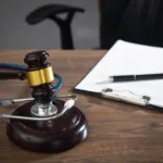 Judge gavel, documents and stethoscope on the wooden table.
